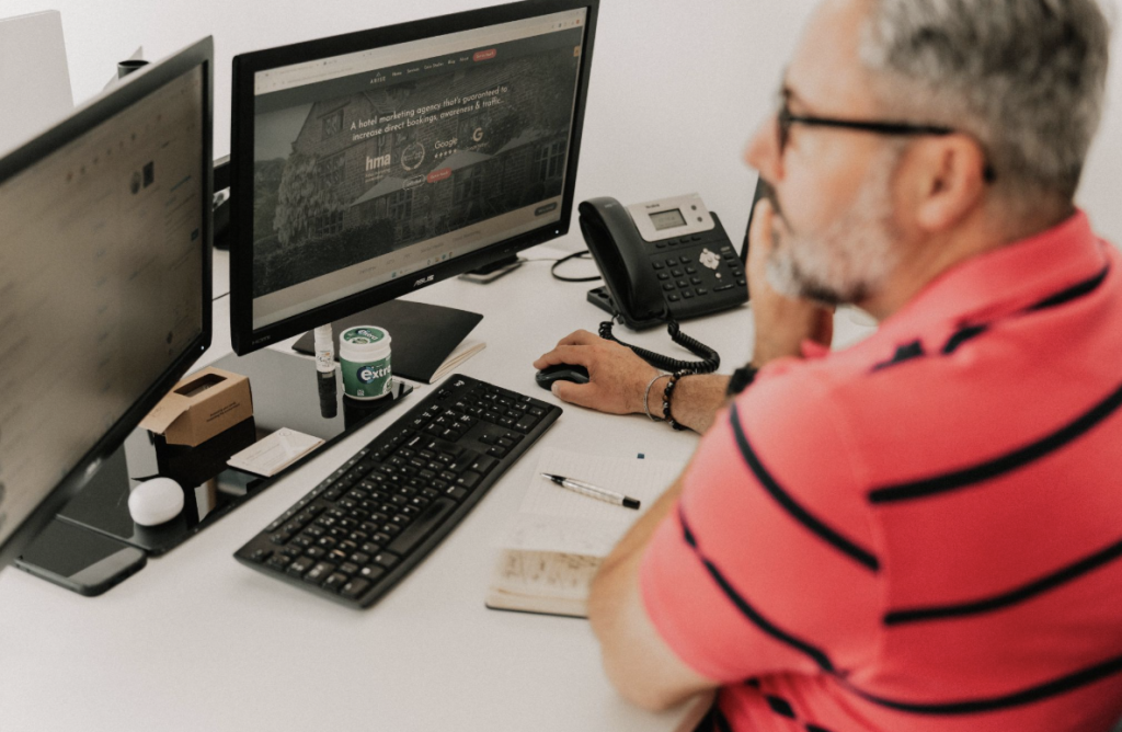 Employee at Arise SEO agency in Sheffield sat at his desk whilst on the phone